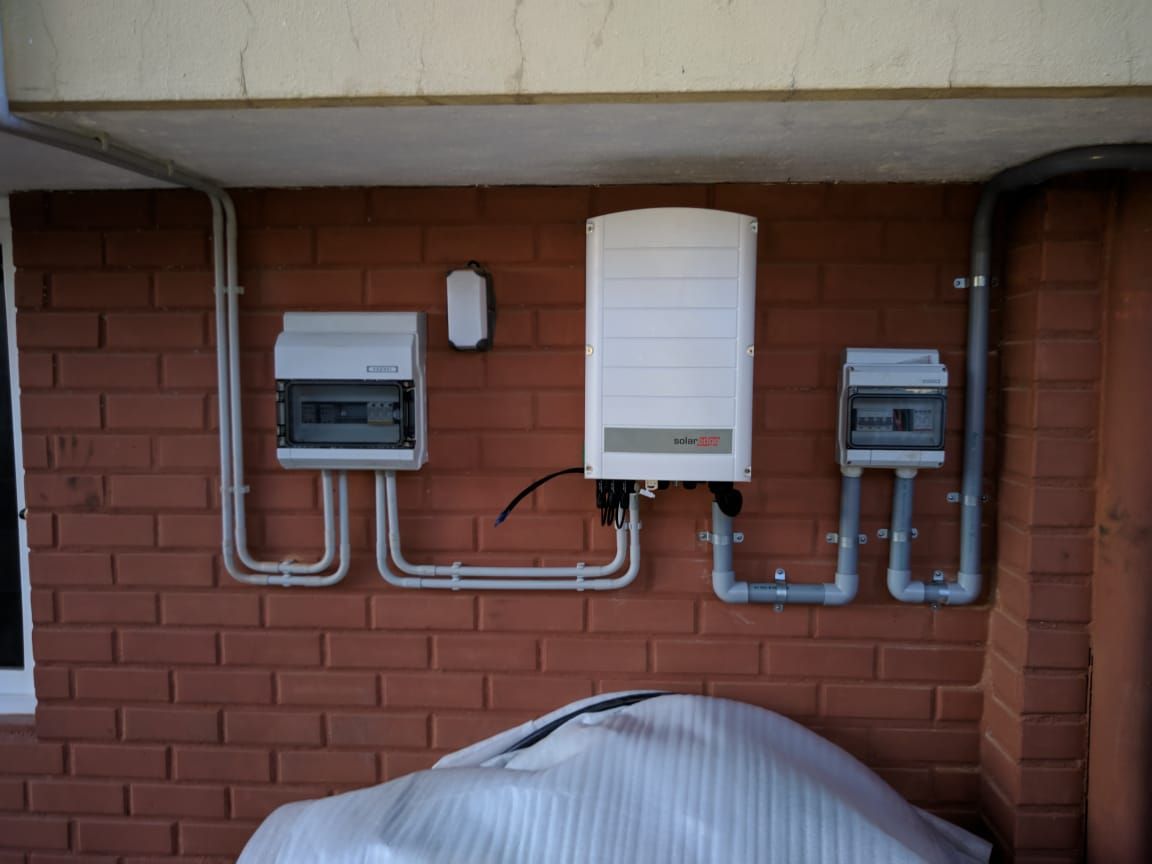 SolarEdge inverter with AC and DC distribution boards mounted on the wall